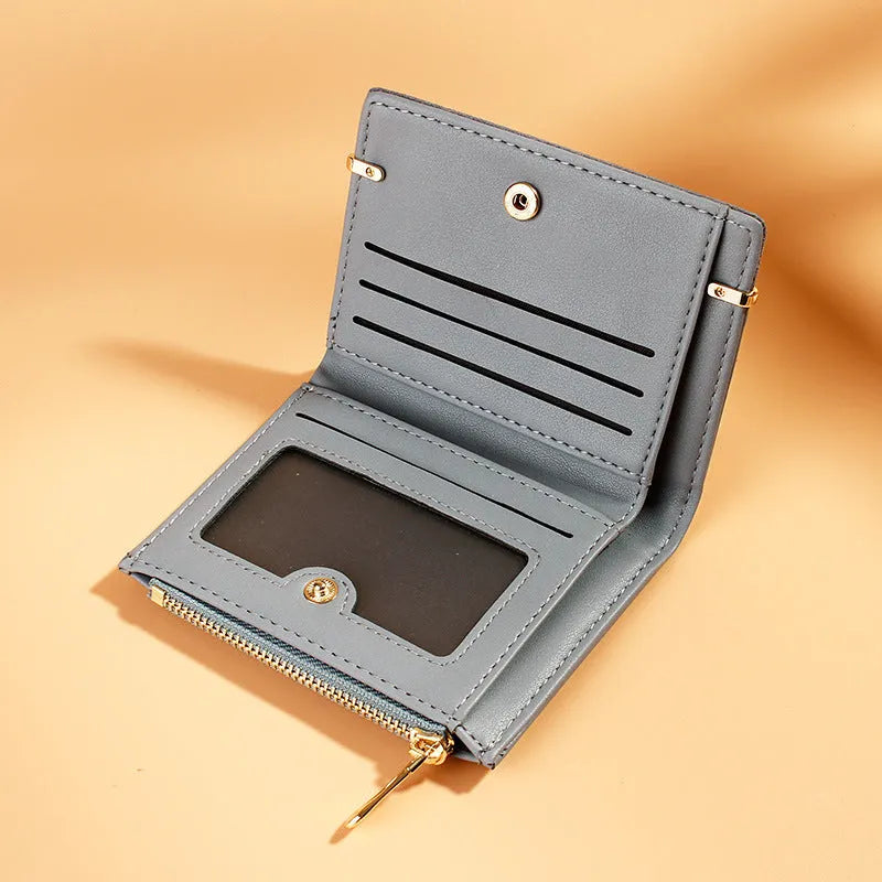 A closed black PU leather ladies wallet with a short zipper, showing its two-fold design.