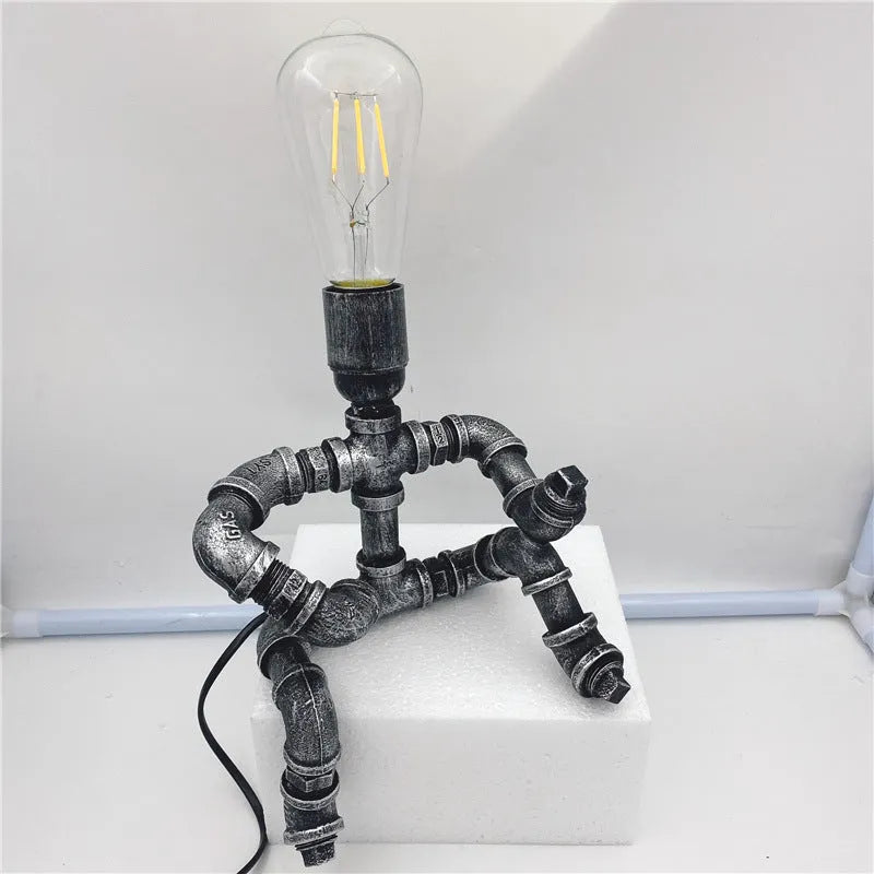 Iron pipe industrial retro robot design table lamp in retro colour on a wooden desk