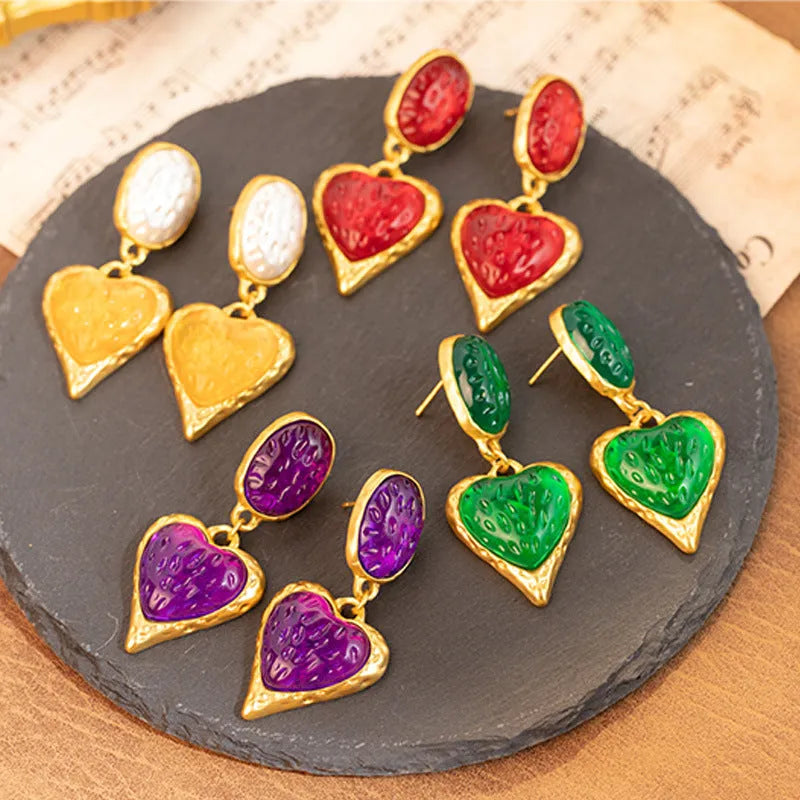 Pleated oval heart-shaped alloy stud earrings on silver posts in purple, red, green, and yellow/white colours.