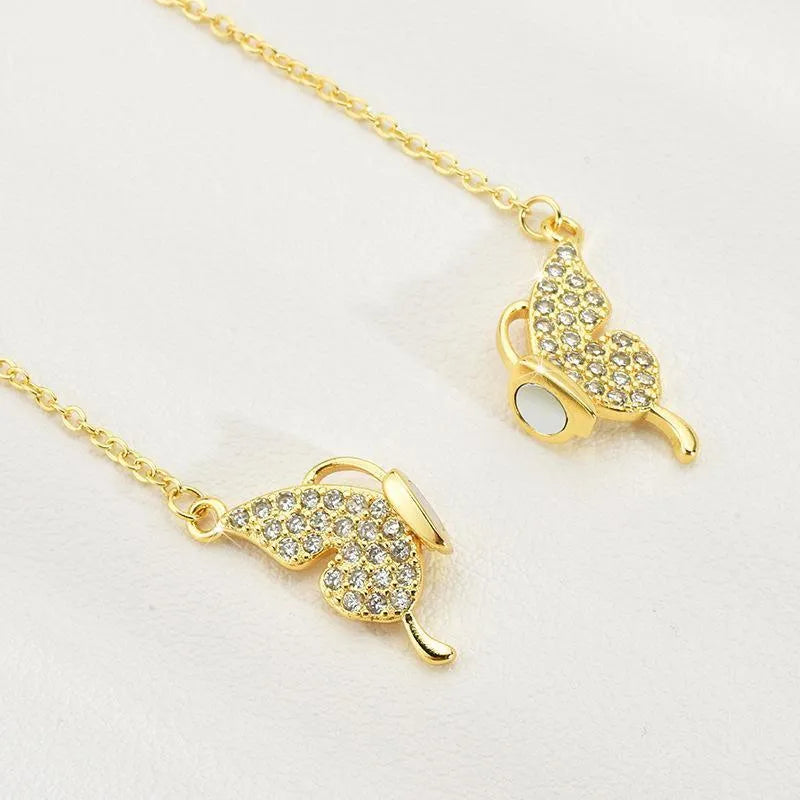 Gold titanium steel women's butterfly charm necklace on a twisted chain with magnetic clasp.