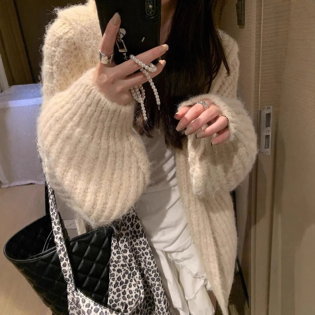 A woman wearing a thick, dark gray retro-style hooded cardigan with regular sleeves.