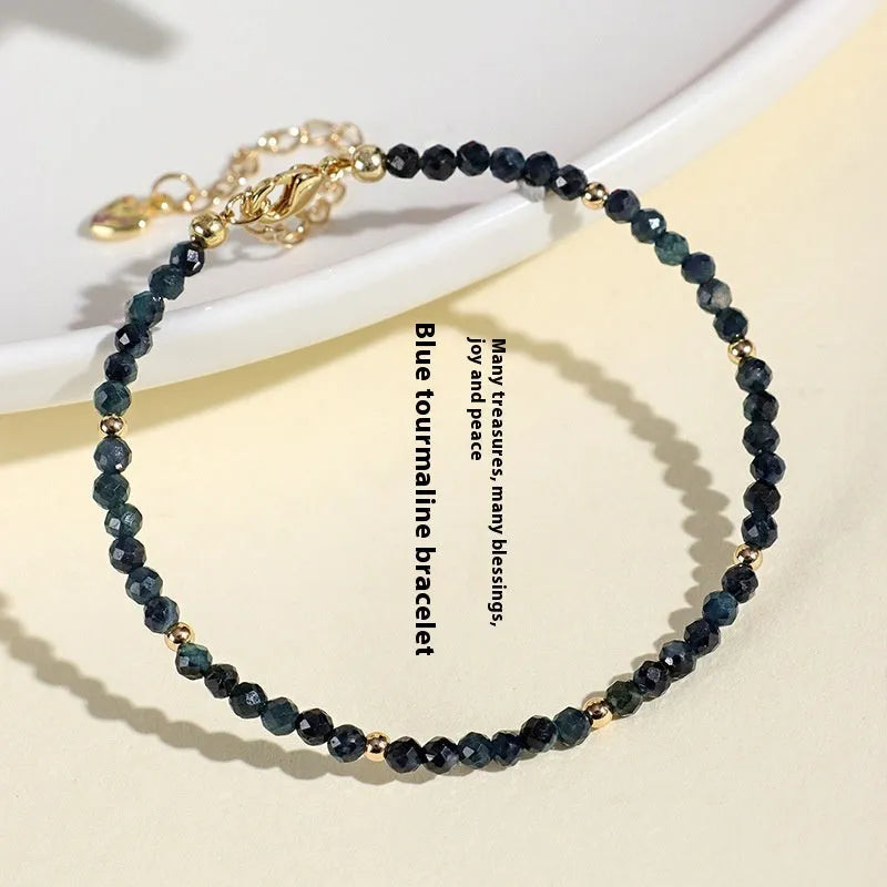 Adjustable blue tourmaline beaded bracelet with spacer beads and gold-colour accents on a wrist.