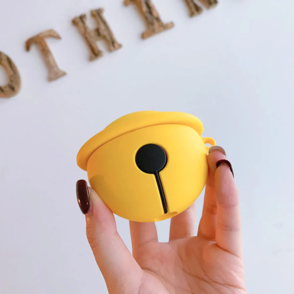 Yellow silicone AirPods case with attached bell charm showing charging port and LED cutouts