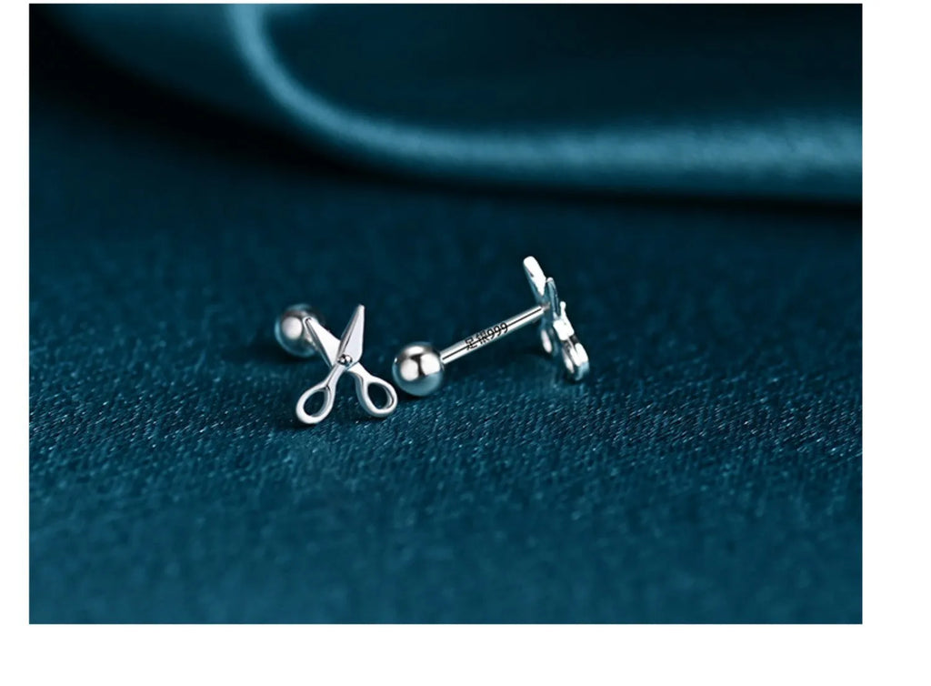 A pair of pure silver earrings with a miniature scissors design and screw-on backs.