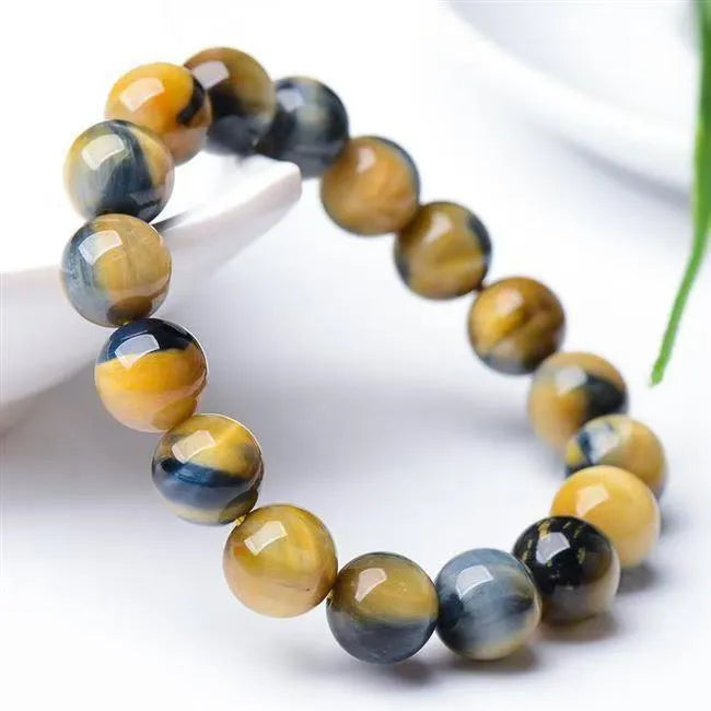 A geometric agate fantasy tigereye bracelet with round beads, shown in unisex styling.