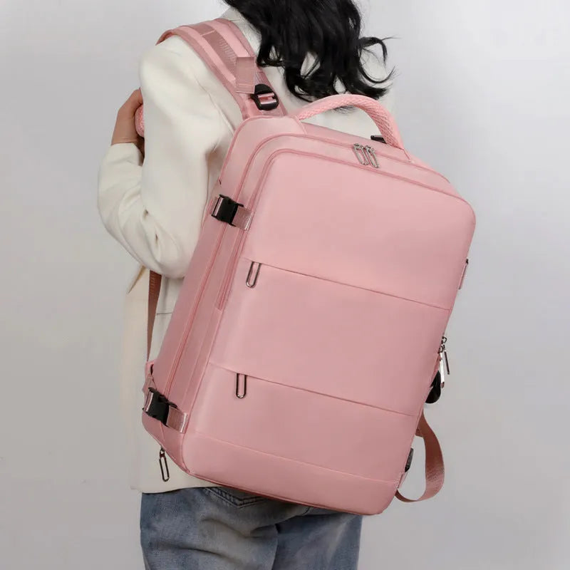 Large purple travel backpack with multiple compartments, shown next to a laptop.