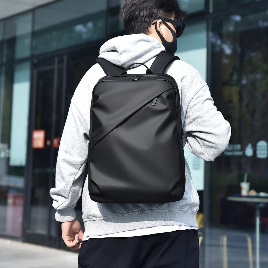 Large waterproof backpack in PU leather with sewing thread detailing, includes computer bag
