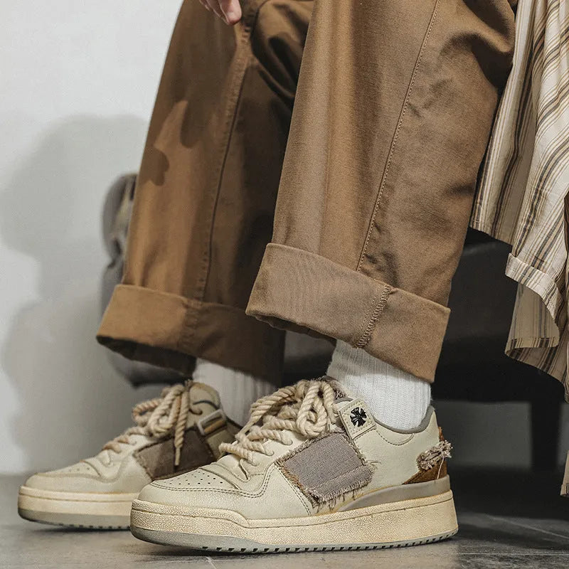 Beige low-top vintage style skateboard shoes with round toe and lace-up front on a rubber sole.