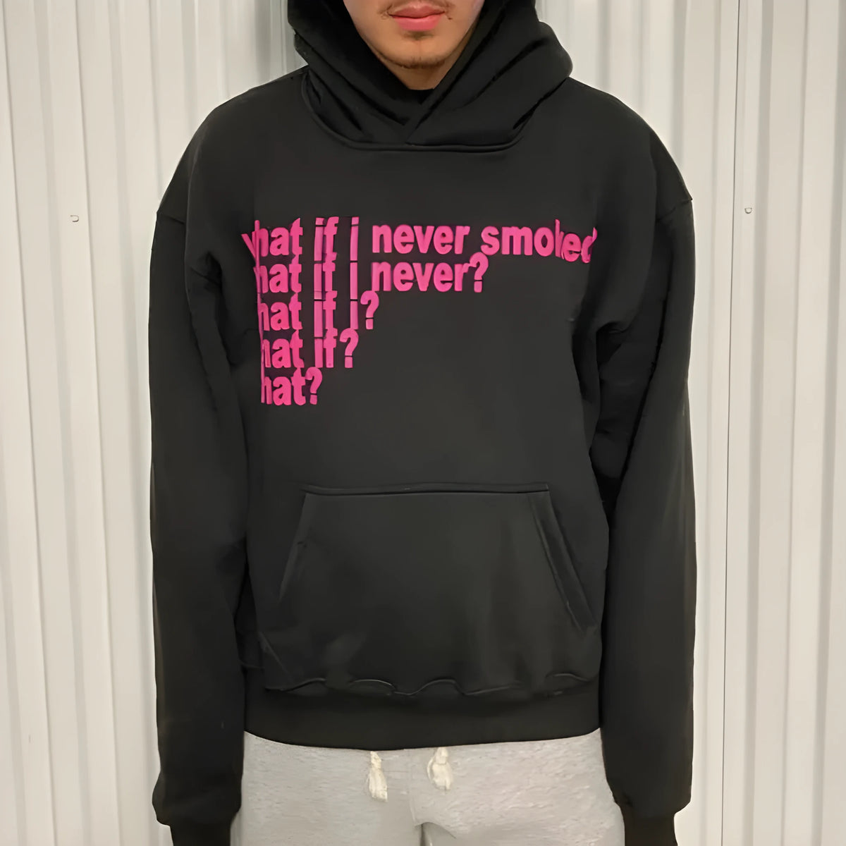 Black hooded sweater with white letter print on front, model wearing size M.