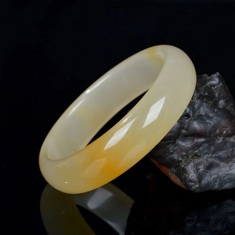 Polished light jade stone bracelet for women on a white background, showing Chinese style and smooth finish.