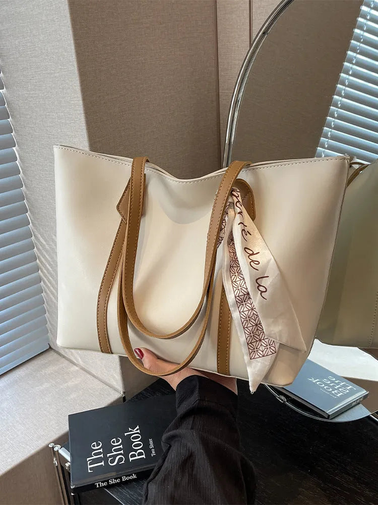 Women's soft bucket shoulder bag in various colours showing crossbody strap and zippered compartment