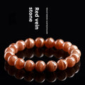 Natural Old Mine Rhodochrosite round bead bracelet with Ruyi design elements on a wrist.
