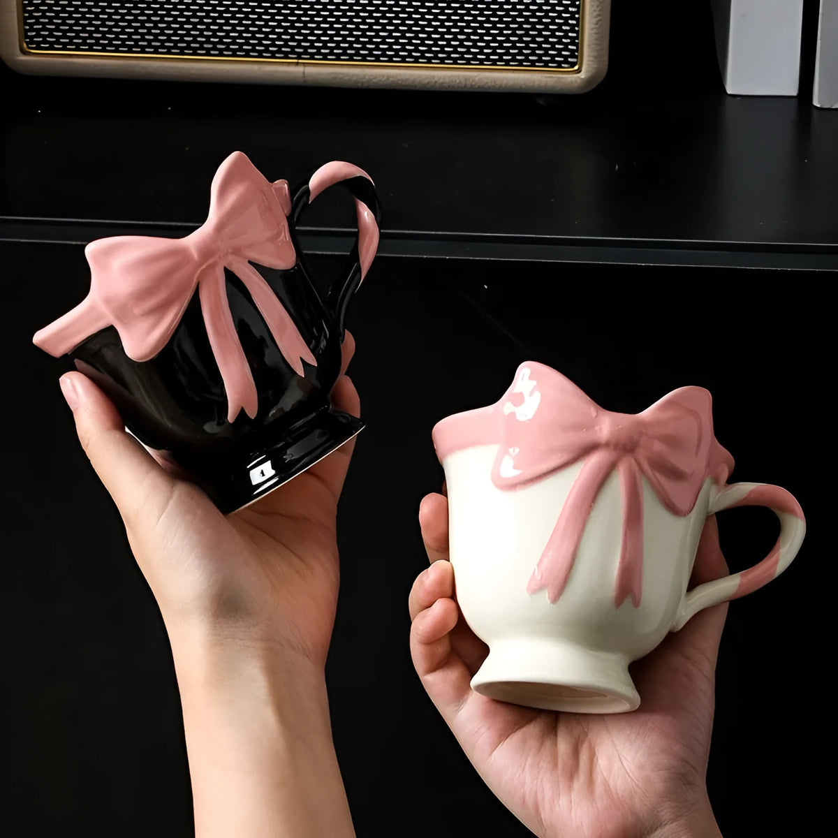 Cute white ceramic mug with a black heart bow design and printed handle ornament.