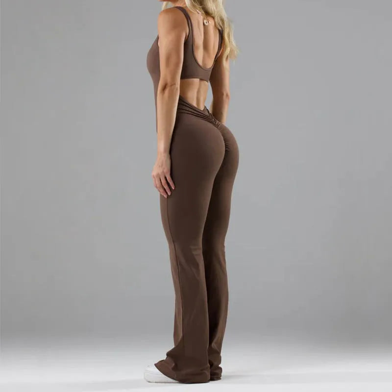 Close-up of a woman wearing a black seamless milk silk jumpsuit with a hollow design and mid-waist fit.