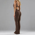 Close-up of a woman wearing a black seamless milk silk jumpsuit with a hollow design and mid-waist fit.