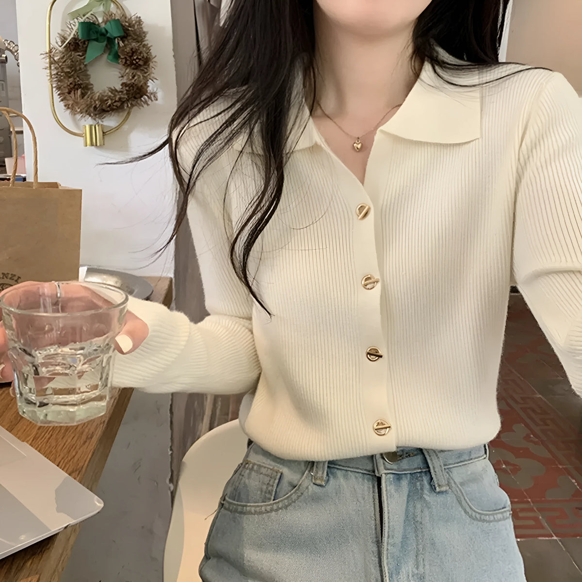 Beige long-sleeved viscose knitted cardigan hanging on a hanger, loose fit