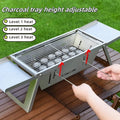 Small folding portable charcoal grill shown set up for an outdoor barbecue.
