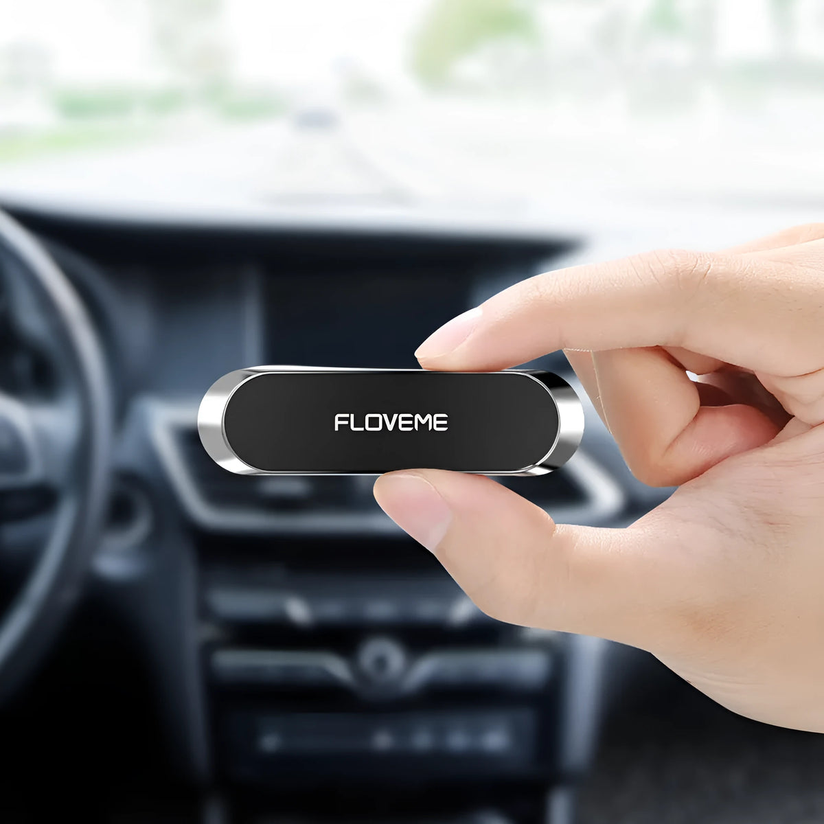 Black magnetic car phone holder mounted on windscreen with silver iron sheet for mobile phone attachment