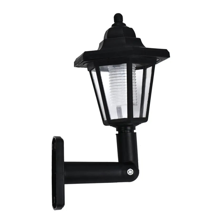 Black hexagonal solar-powered wall lamp for outdoor garden use, shown mounted on a fence