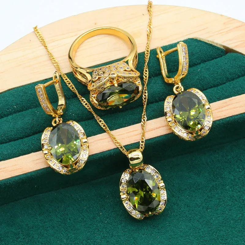 Olive green zircon jewellery set with snake bones chain necklace, matching earrings, and ring on a copper base.