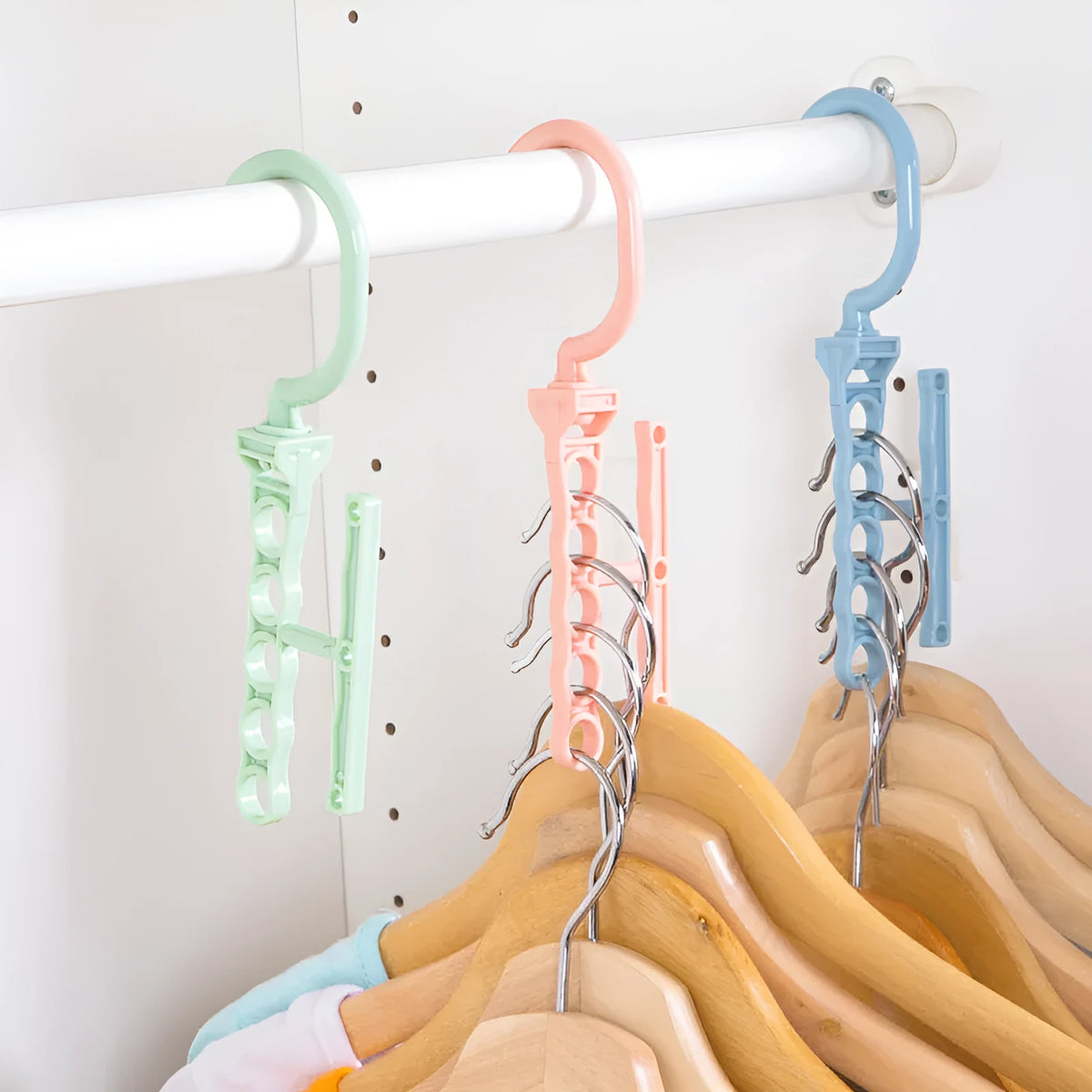Blue revolving wardrobe hanger with five rotating branches and a handle.