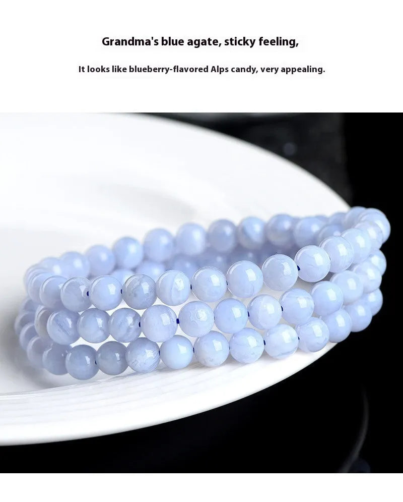 Blue agate bead bracelet with striped pattern and ruyi design on a white background.