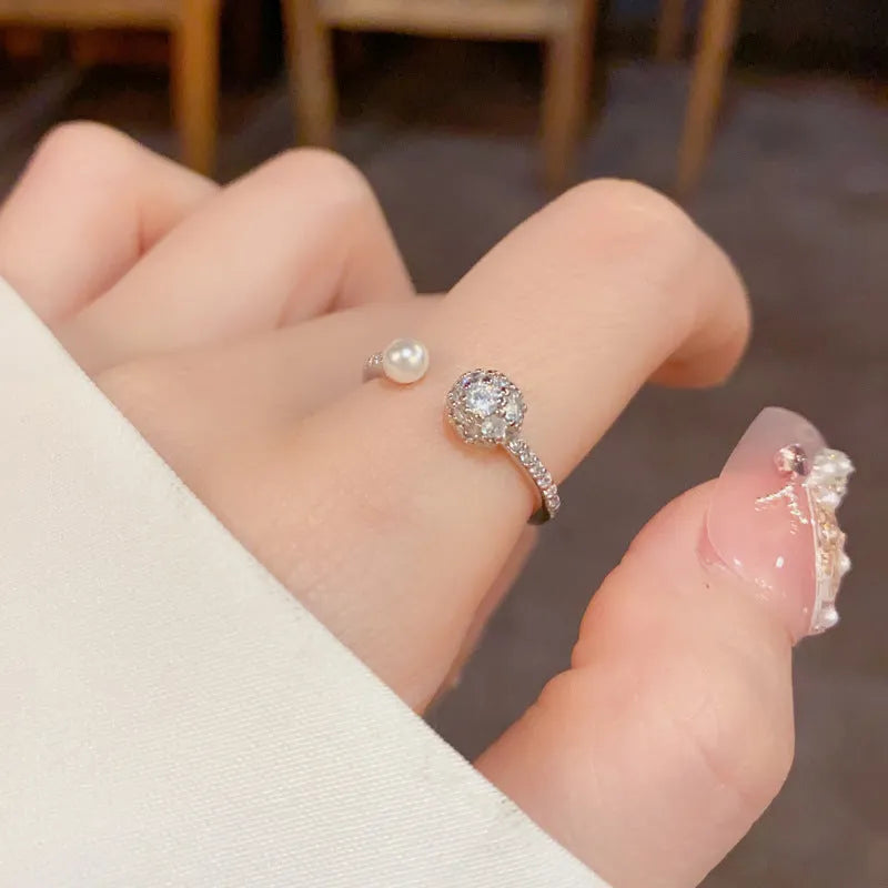 Open-end women's ring with round zircon detailing and pearl elements in gold or silver plated finish