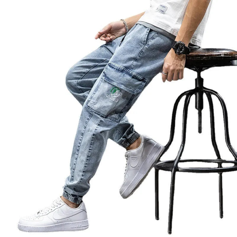 Man wearing straight leg cotton cargo jeans in blue, showing mid waist and skinny open leg style.