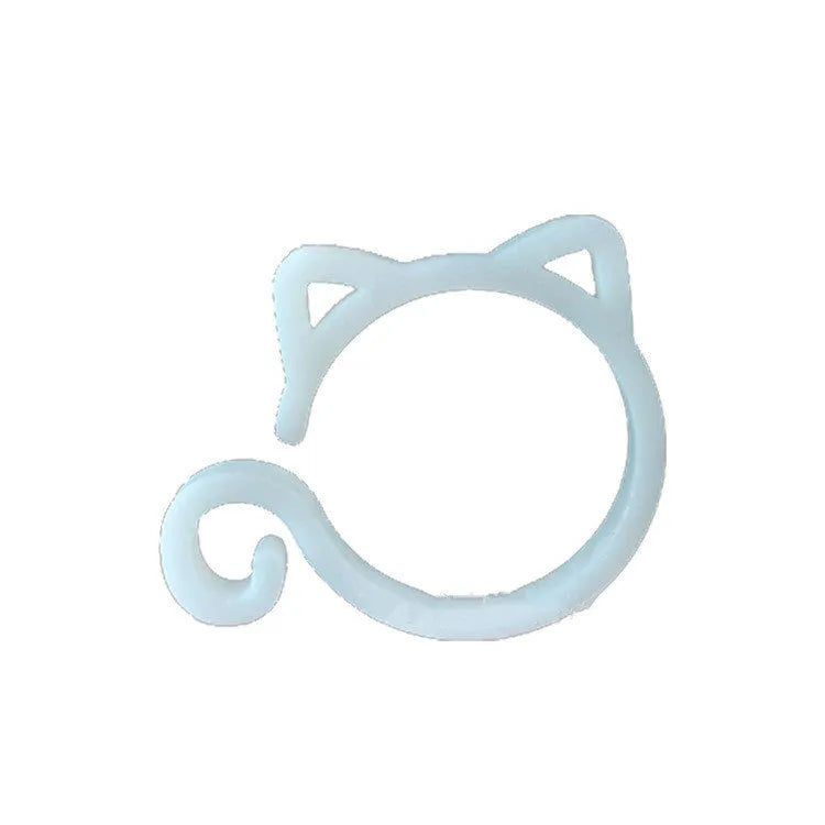 Colourful plastic cat-shaped plant clip for gardening support on a green leaf.