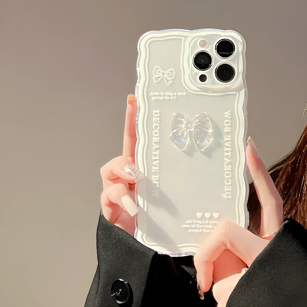 Transparent iPhone mobile phone case with a three-dimensional white bow design on the back.
