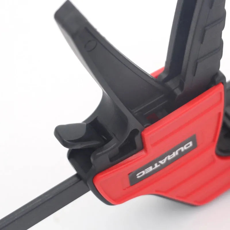 Plastic woodworking clamp with quick-release trigger and soft rubber contact surfaces