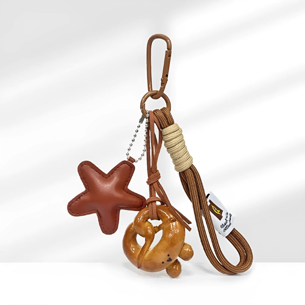 Brown soda bread handbag pendant with cartoon croissant design and carrying strap