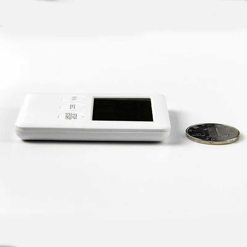 Black and white digital kitchen timer with magnetic back and display showing time