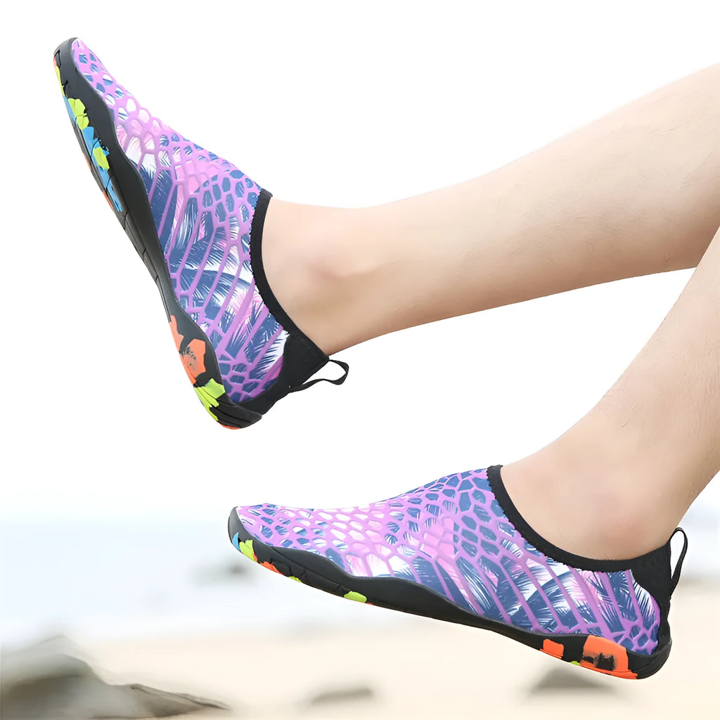 Pair of blue Lycra beach wading shoes with EVA midsole on a sandy beach background.