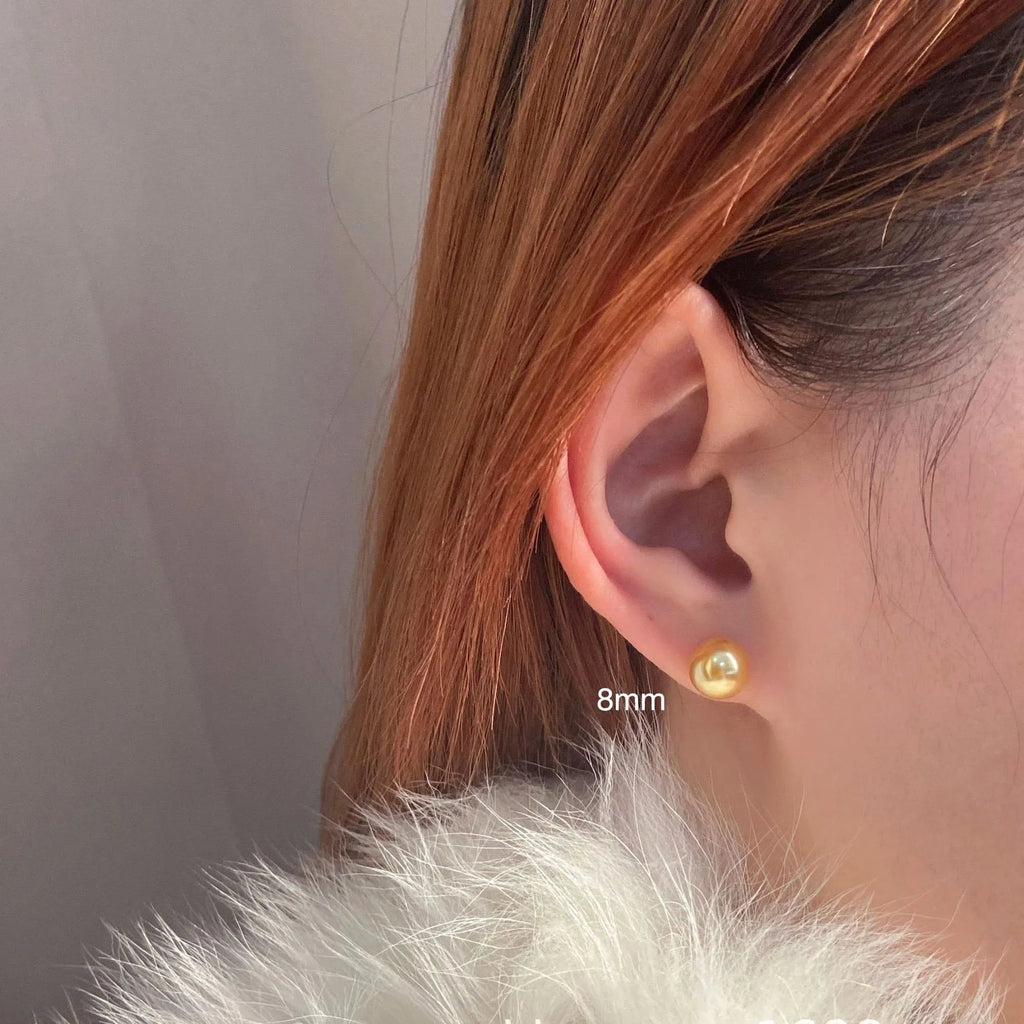Geometric pearl stud earrings with eight-pointed star design in silver setting