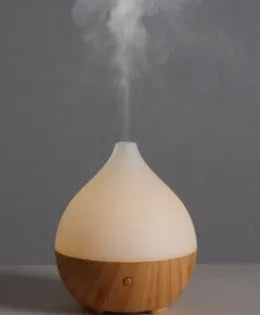 Wood grain finish vase-shaped aroma diffuser with 100ml water tank capacity.