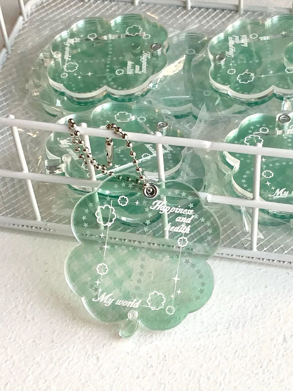 Four-leaf clover shaped acrylic phone pendant keychain in blue, green, and mint colour variations