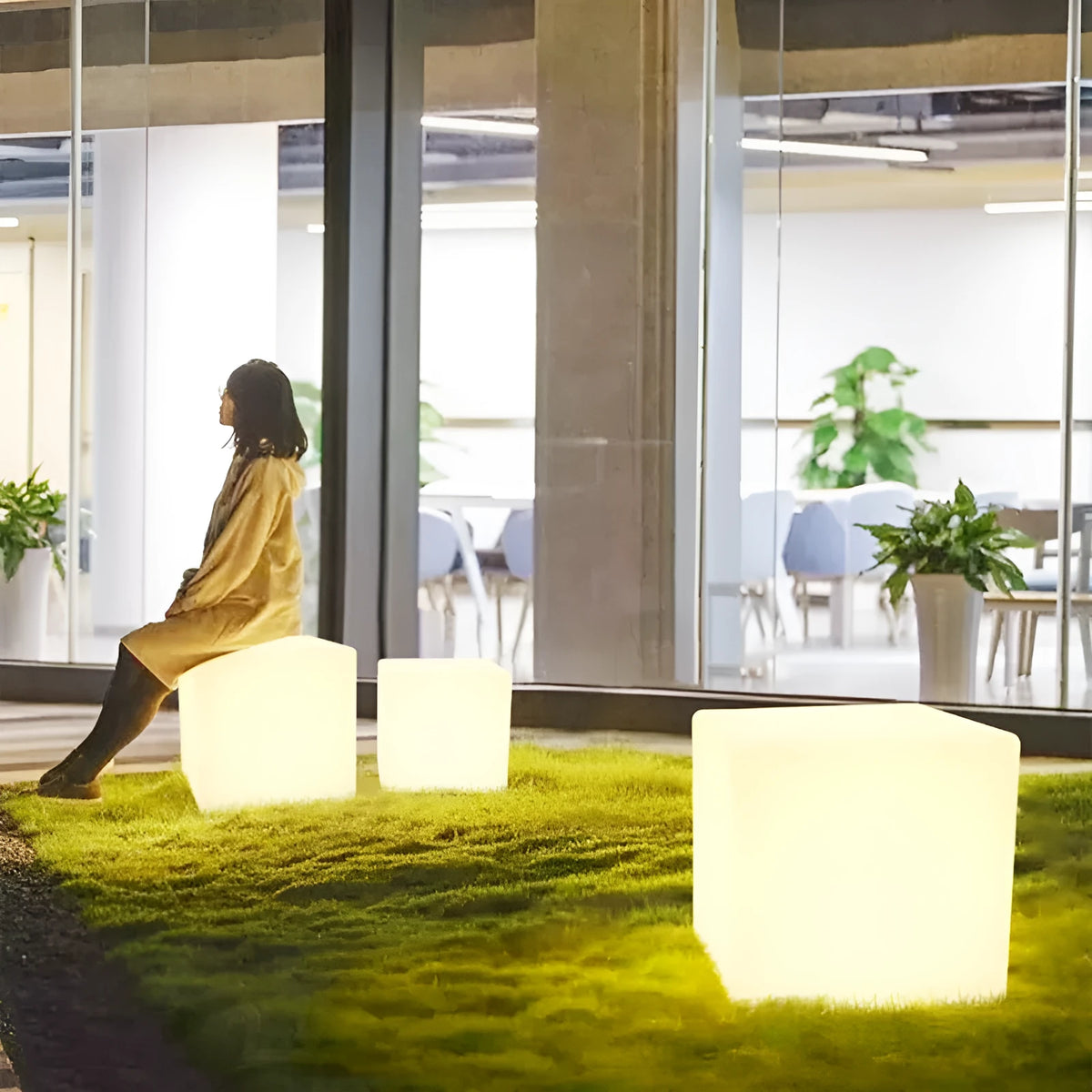 Modern white LED cube stool light outdoors, showing clean square design and soft illumination.