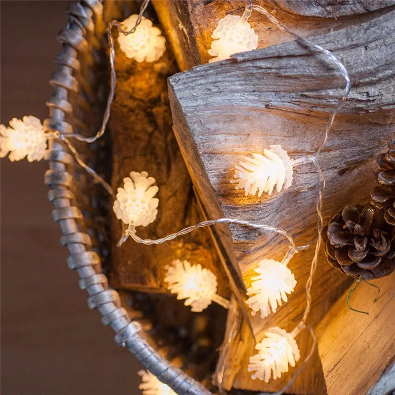 Warm white LED pine cone light string hanging decoratively, showing plastic shell details.