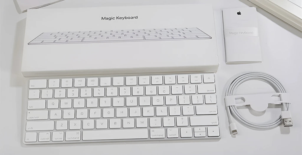 White genuine Apple Bluetooth wireless keyboard with ultra-thin metal casing on a desk.