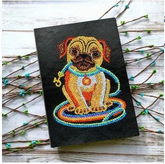 Black A5 diamond painting notebook with elastic closure showing open pages for craft organisation