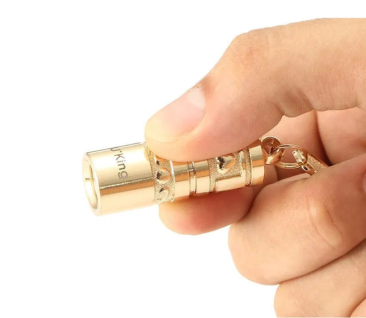 Gold-coloured zinc alloy mini LED keychain flashlight with a keyring.