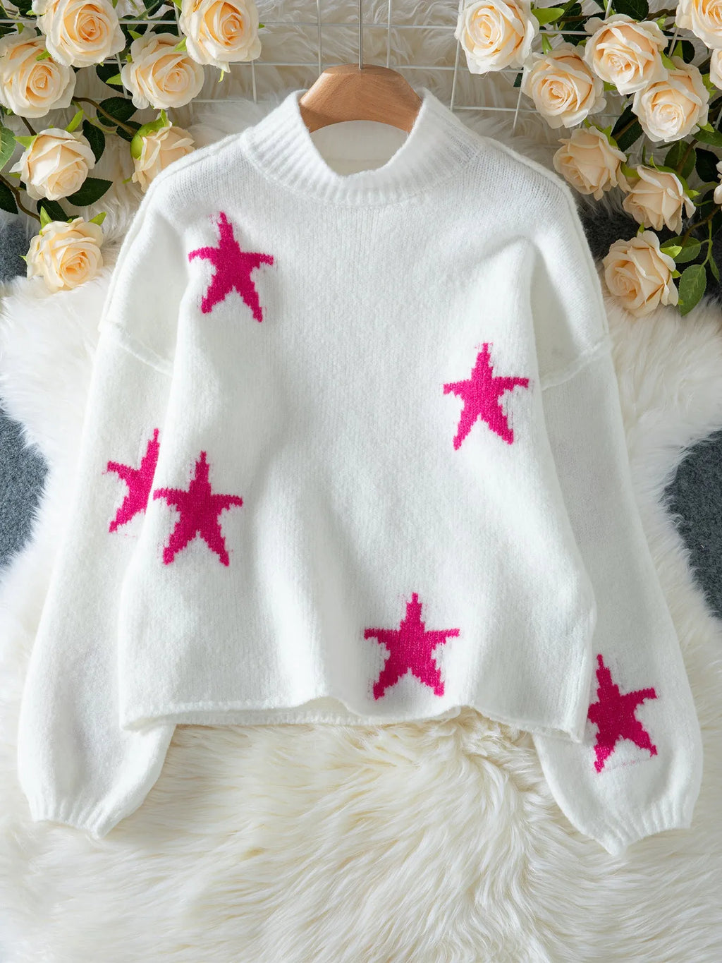 White loose women's turtleneck pullover with a black five-pointed star pattern on the front.