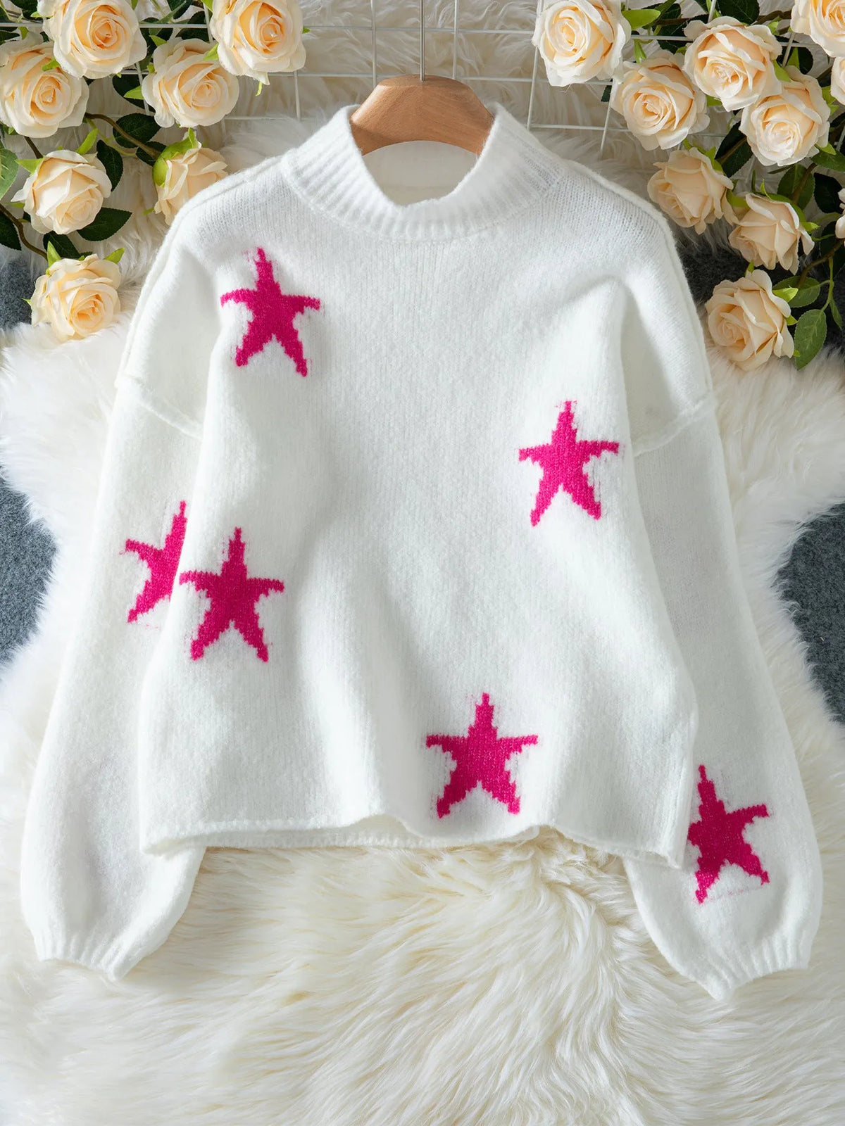 White loose women's turtleneck pullover with a black five-pointed star pattern on the front.