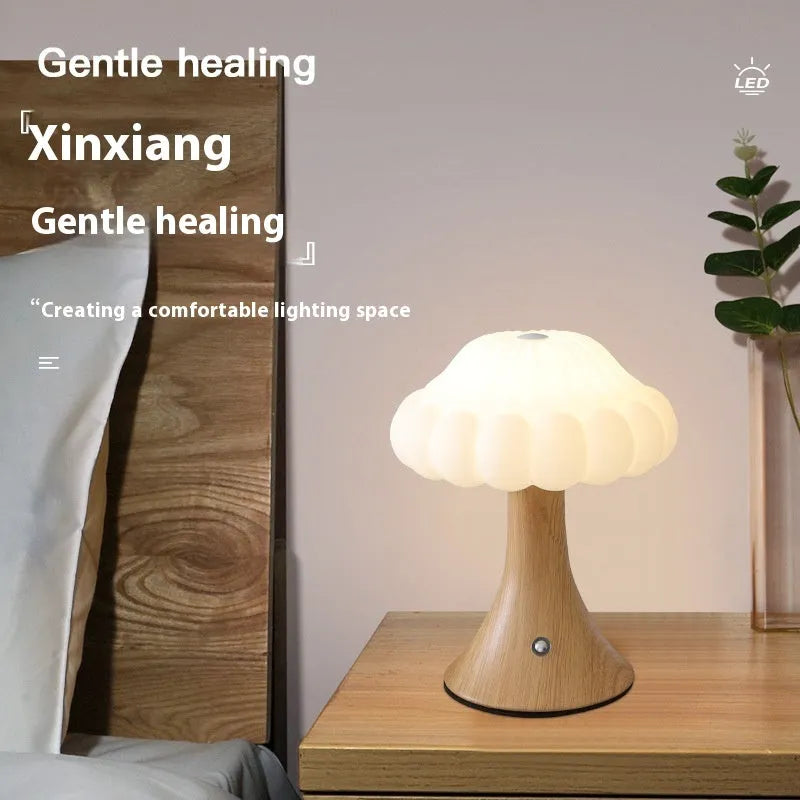 Wood grain coloured mushroom-shaped touch night lamp on a wooden table.