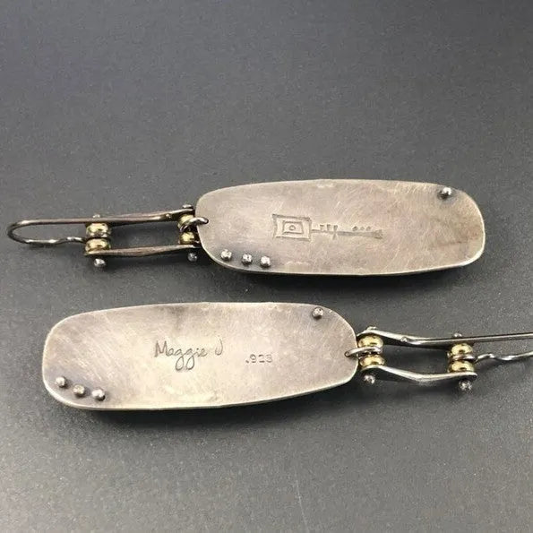 A pair of silver and grey geometric drop earrings with a marble stone pattern on a white background.