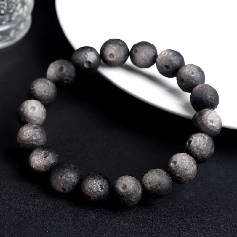Obsidian ball bracelet with natural crater texture in silver stone meteorite colour with grinding finish