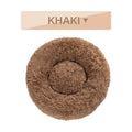 Fluffy donut-shaped dog bed in long plush material, shown in one of multiple available colours