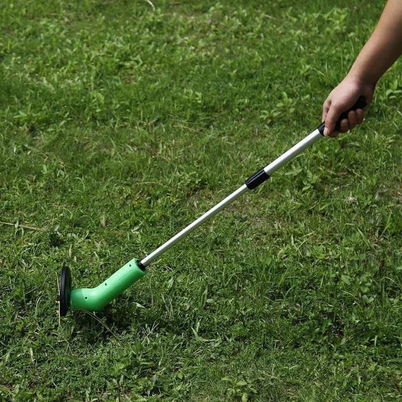 Cordless handheld lawn trimmer with extension pole and protective shield on a garden lawn.