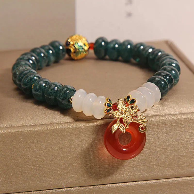 Blue jade and red agate bead bracelet with a crystal peace buckle closure.
